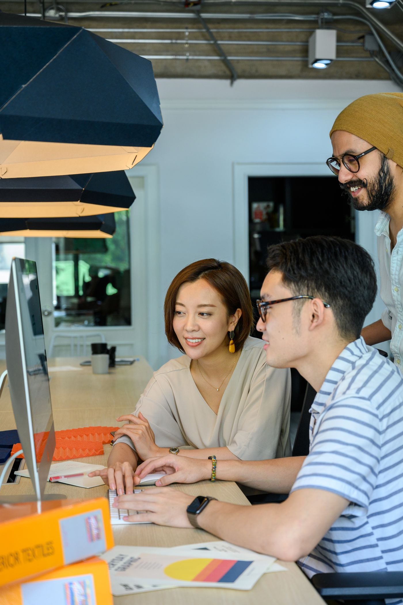 Two colleagues talking through a book project at a computer screen